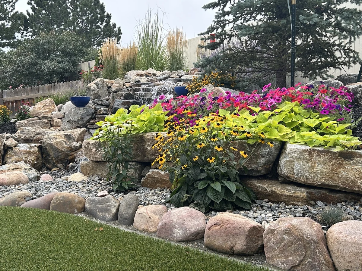 Flowering beds, decorative boulders, and lawn in an Outdoor Legacy owner-uploaded photo